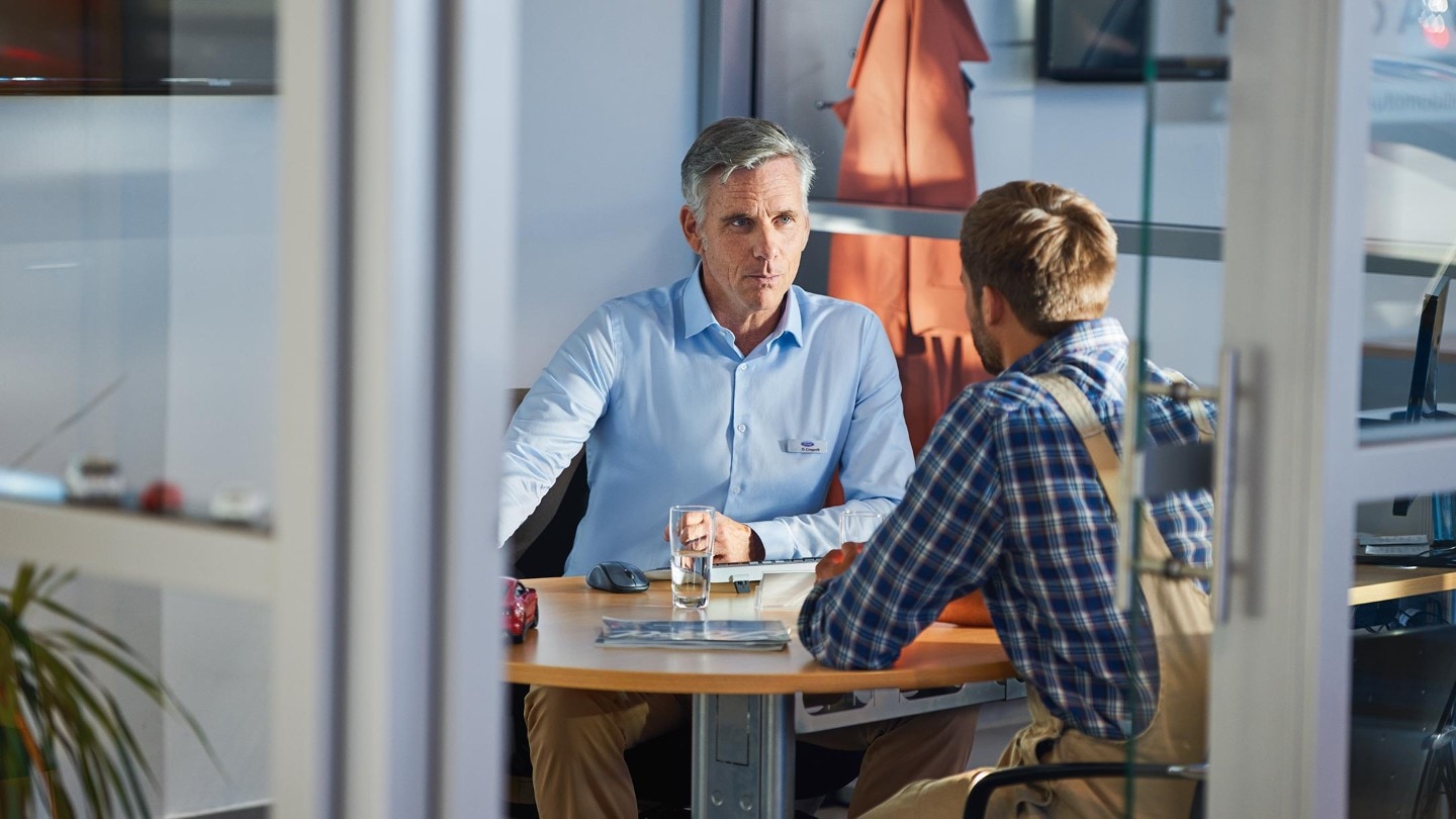 Twee Mannen In Gesprek aan een bureau