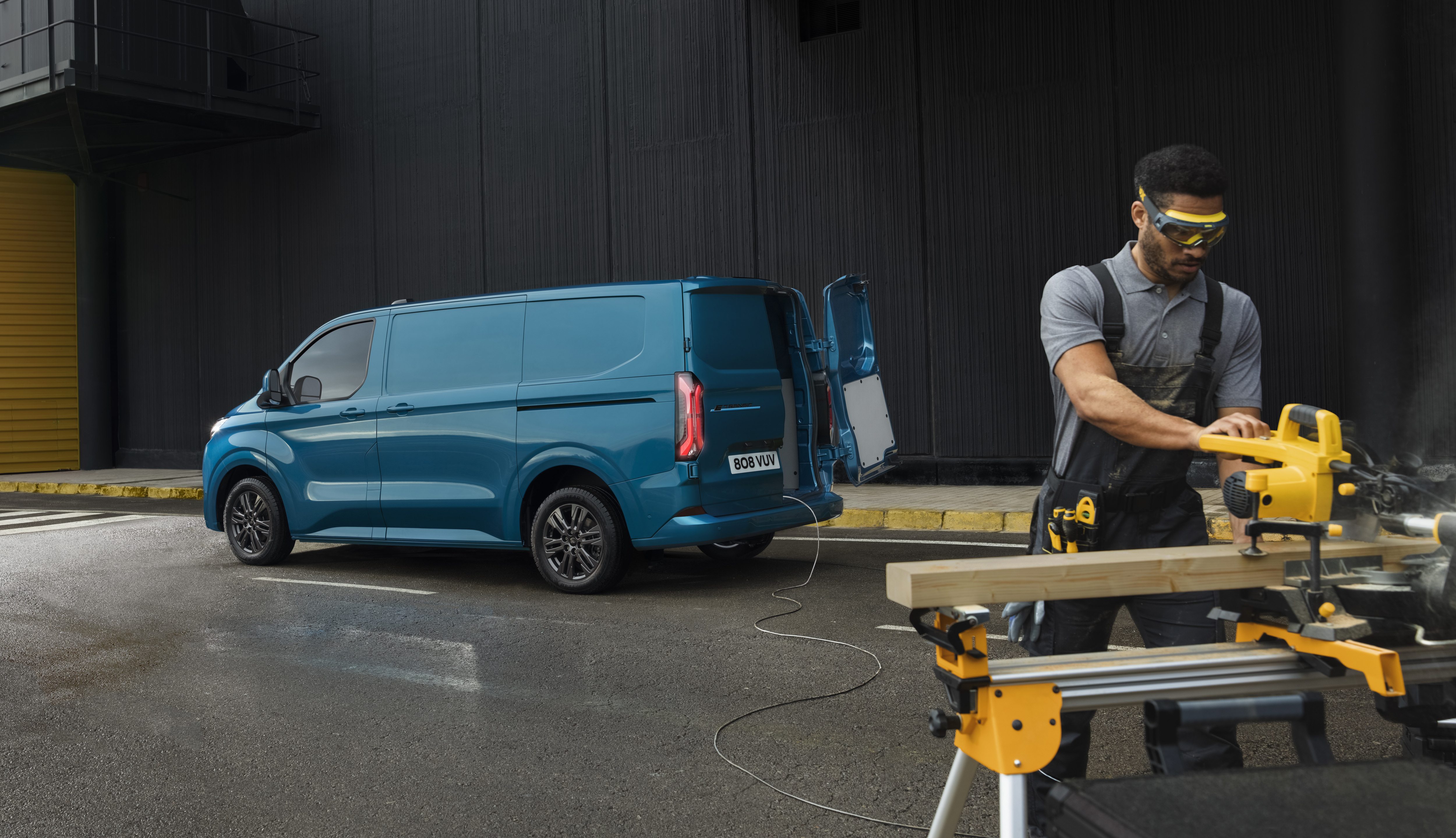 Ford E-Transit Custom met een man die aan het klussen is